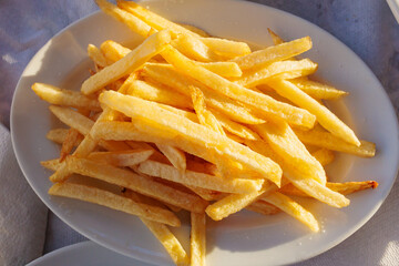 Crispy golden French fries served in a casual outdoor setting during a sunny afternoon