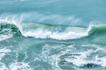 Fototapeta premium Wave splashing close-up. Crystal clear sea water, in the ocean in San Francisco Bay, blue water, pastel colors.