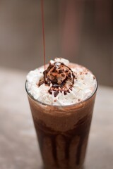 Frappe de café con crema batida y chocolate líquido con fondo difuminado. 