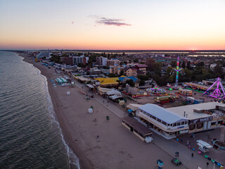 Obraz premium Aerial drone view from above of the center resort town with shops, restaurants and entertainment, hotels and an amusement park near sandy beach on Black sea in Zatoka resort, Odessa region, Ukraine
