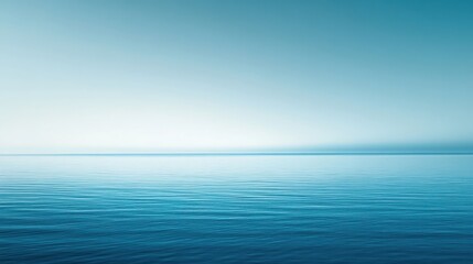 Obraz premium A serene view of calm ocean water blending into a clear blue sky.