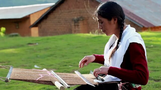 Mujer peruana campesina atractiva  trabajando en la producci&oacute;n tradicional de tejido de manta lana hecha a mano.Cercano al tejido en Per&uacute;.
