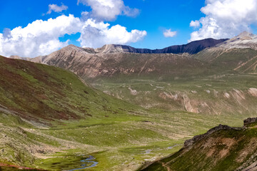 Fototapeta premium Beautiful mountain scenery. River, valley, snow, blue sky, white clouds. In-depth trip on the Sonamarg Hill Trek in Jammu and Kashmir, India