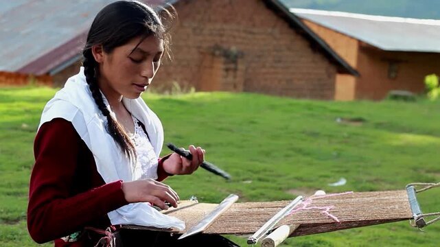 Mujer peruana campesina atractiva  trabajando en la producci&oacute;n tradicional de tejido de manta lana hecha a mano.Cercano al tejido en Per&uacute;.