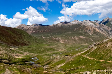 Obraz premium Beautiful mountain scenery. River, valley, snow, blue sky, white clouds. In-depth trip on the Sonamarg Hill Trek in Jammu and Kashmir, India