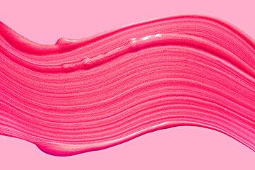 Glittering shimmering lip gloss texture swatch on pink isolated background