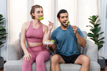 Fototapeta premium Healthy sporty and vegetarian couple in sportswear with a bowl of fruit and vegetable. Healthy cuisine nutrition and vegan lifestyle for fitness body physique at gaiety home concept.