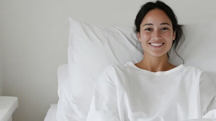 A cheerful young woman relaxes in a cozy hospital bed, showcasing her bright smile