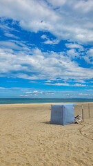 Beach stripped blue and white tent on e white sand, on the coast of the ocean or sea. In the...