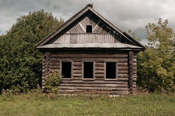Fototapeta premium An old log cabin is situated in the middle of a grassy field