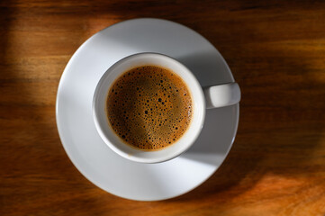 A cup of coffee sits on a wooden table