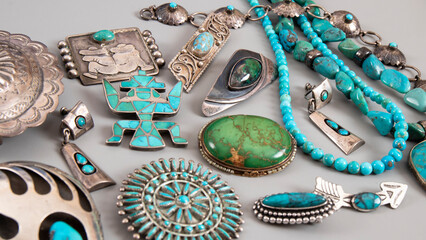 Variety of old jewelry with turquoise in silver. American native brooches, beads and earrings. Isolated handmade Indian jewelry close up. Navajo art.