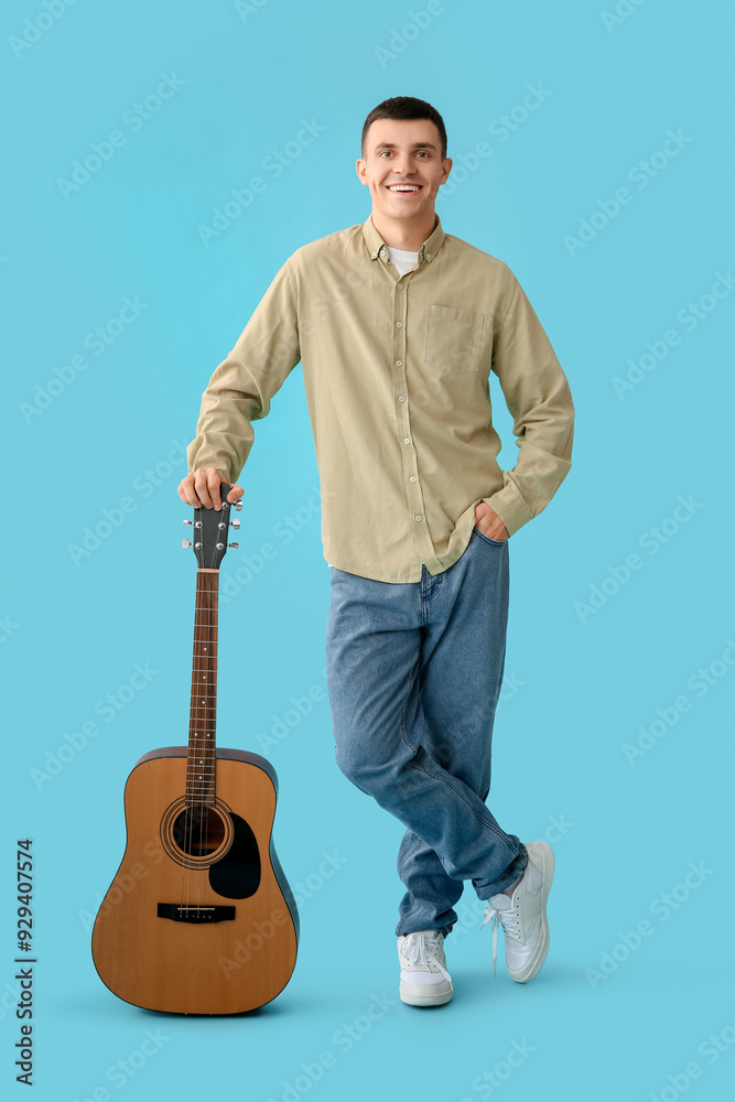 Sticker Handsome young man with guitar on blue background