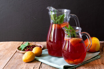 Drink with fruits in a jug. Berry compote. Refreshing drinks for summer made from berries