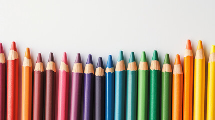 Fototapeta premium A row of colorful, sharpened pencils arranged neatly side by side on a white background, creating a vibrant and cheerful spectrum of hues.