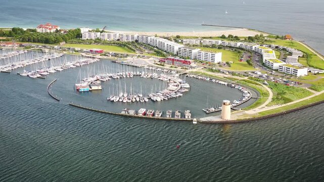 Moored houseboats, sailing boots and yachts in the marina at Burgtiefe, Fehmarn, Schleswig-Holstein, Germany. Numerous moored sailboats and houseboats set against the  waters of the Baltic Sea.