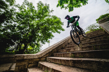 Male freerider on a bicycle quickly descends the city stairs. High-speed descent on a mountain bike...