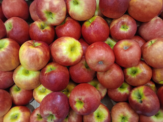 Fresh red apples for the background. Ripe juicy apples laid out on the counter in the store.