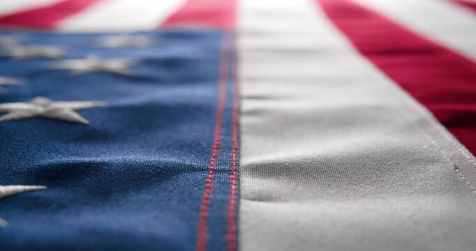 Panning across a brightly lit, red white and blue, US American flag and slowly fading to white. Background for Memorial Day, Veteran's Day, 4th of July, or other patriotic USA holiday.