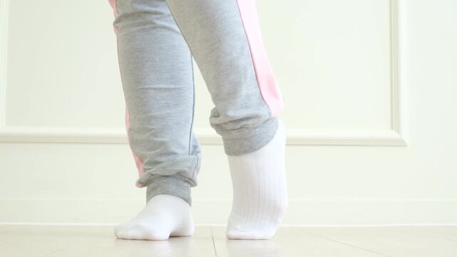 Legs doing exercises and stretching feet on white background front view.