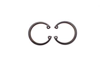 Black circlip retaining rings scattered on a white background.
