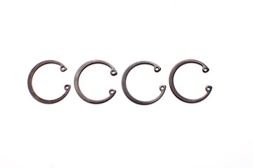 Black circlip retaining rings scattered on a white background.