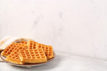 Plate with tasty Belgian waffles on grey table