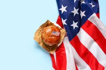 Tasty burger with flags of USA on blue background. American Independence Day celebration
