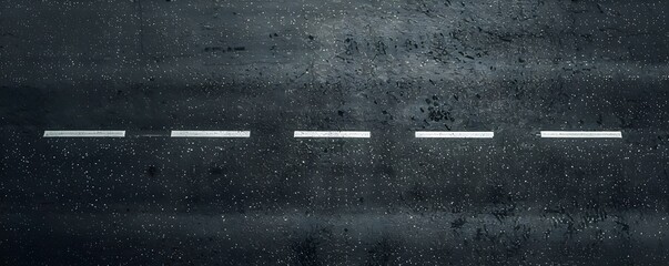 A Wet Asphalt Road with White Lane Markings and Raindrops