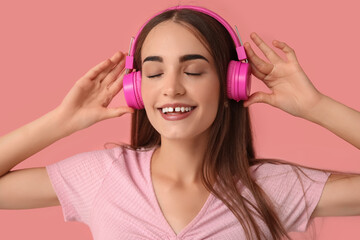 Young woman in headphones with diastema on pink background, closeup