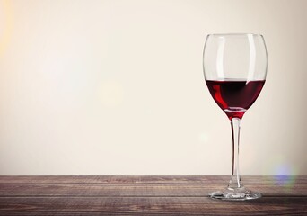 Red wine in glass on color background.