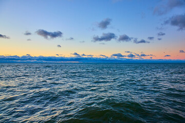 Obraz premium Serene Lake Michigan Sunrise with Gentle Waves from Shoreline Perspective