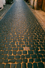 Fototapeta premium Pavement road. Stone cladding. Rough brick road. Cobblestone pavement background. Textured background. Sidewalk. Road. Old cobblestone road.