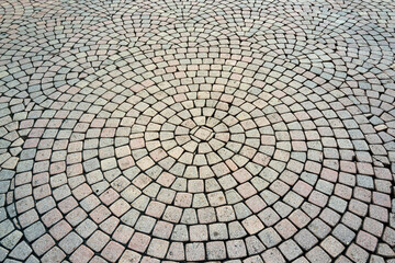 Stone road texture. Stone walk background. Granite cobblestoned pavement background. Rough brick road. Side walk. Stone cladding pavement.