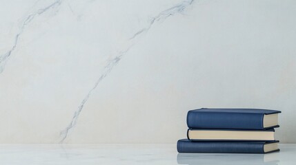 A stack of three navy blue books on a marble surface against a light marble background.