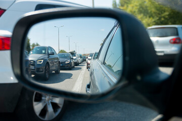 The image of a large traffic jam in the rearview mirror