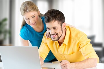 Happy young couple with laptop for finance planning