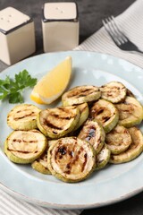 Tasty grilled zucchini slices served on grey table