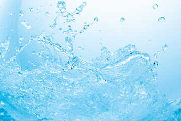 青の背景に波のように舞う水しぶき.