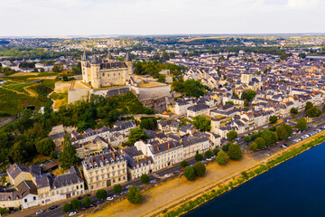Obraz premium Scenic aerial view of Saumur town on banks of Loire in western France overlooking ancient castle and parish church in summer..