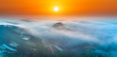Aerial view of Xuan Tho suburbs near Da Lat city at morning with misty and sunrise sky. This place is considered most beautiful and peaceful place to watch sunrise in highlands of Vietnam