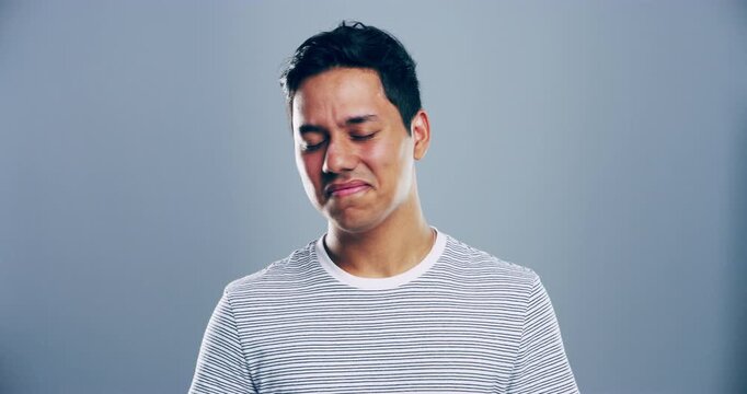 Sad, indian man and crying in studio for depression, crisis and mourning loss of broken heart, death or ptsd on grey background. Disaster, trauma or emotional pain of grief, mental health or break up