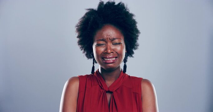 Depression, crying and sad black woman in studio for death, sorrow or mourning loss of broken heart, bad news or crisis on grey background. Unhappy model, emotional pain and tears for grief of trauma
