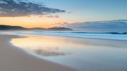 Fototapeta premium A serene beach at sunrise, showcasing soft waves and a colorful sky.