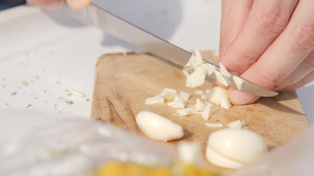 Chopping garlic on the small wooden board
