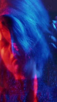 Vertical video. Split mind. Defocused silhouette. Neon red blue light woman mental fear barrier trap shiny reflection double exposure out of focus.