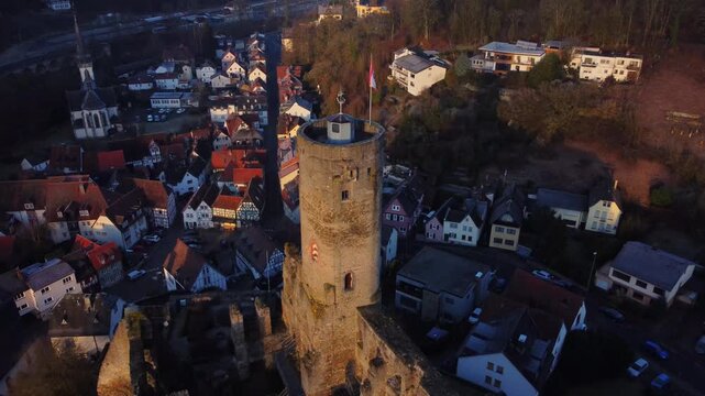 Drone footage of Eppstein Castle and medieval old town in Germany at sunrise. The serene morning light highlights historic architecture of castle and medieval town of Europe. Shots: Fly Back