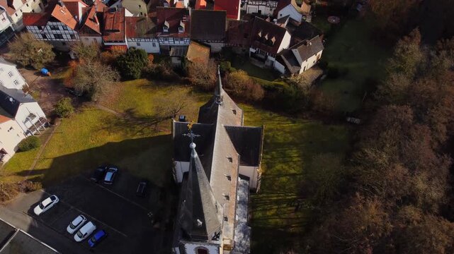 Drone footage of Eppstein Castle and medieval old town in Germany at sunrise. The serene morning light highlights historic architecture of castle and medieval town of Europe. Shots: Tilt Down