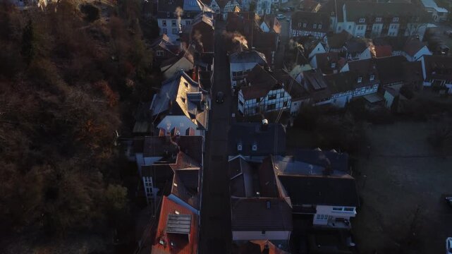 Drone footage of Eppstein Castle and medieval old town in Germany at sunrise. The serene morning light highlights historic architecture of castle and medieval town of Europe. Shots: Move In, Tilt Up
