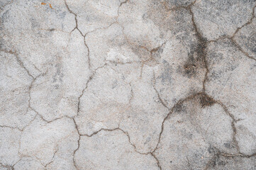 A fragment of a gray concrete wall with scratches and cracks